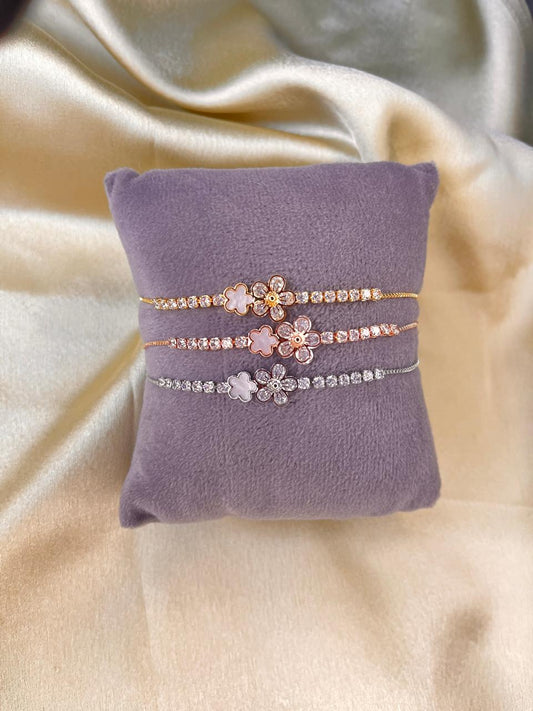 Two floral-patterned bracelets on a purple cushion with a beige fabric background